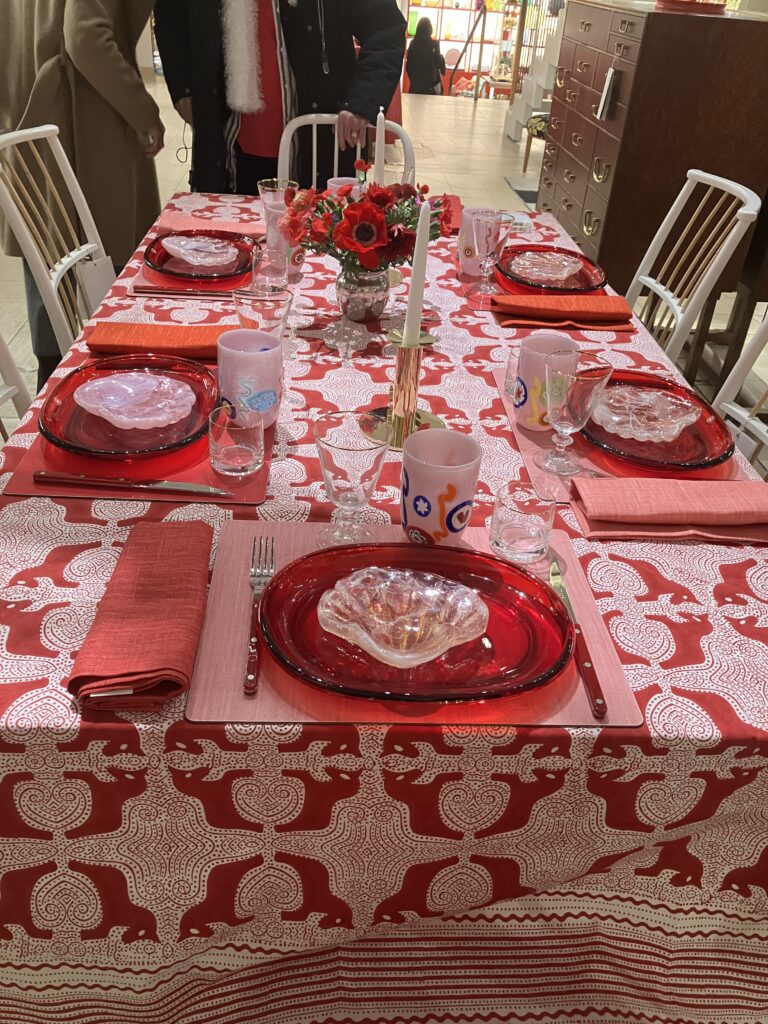ett uppdukat bord i rött med föremål från Svenskt Tenns julkollektion